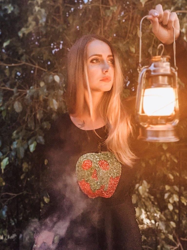 Model wearing green and red poison apple sequin sweatshirt